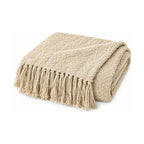 Beige knitted throw with tassels, folded product shot on a white background