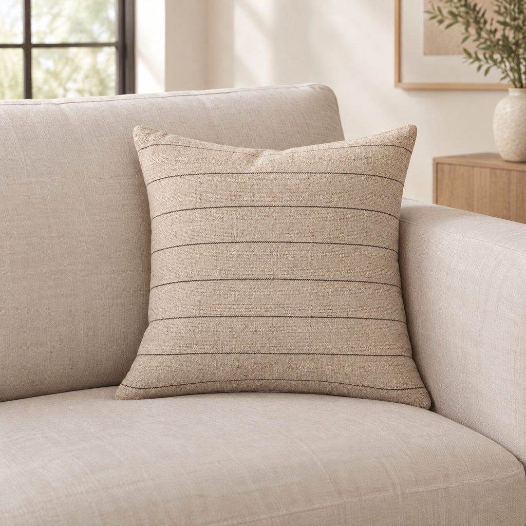 Keisha natural and brown cushion on a sofa to show its size