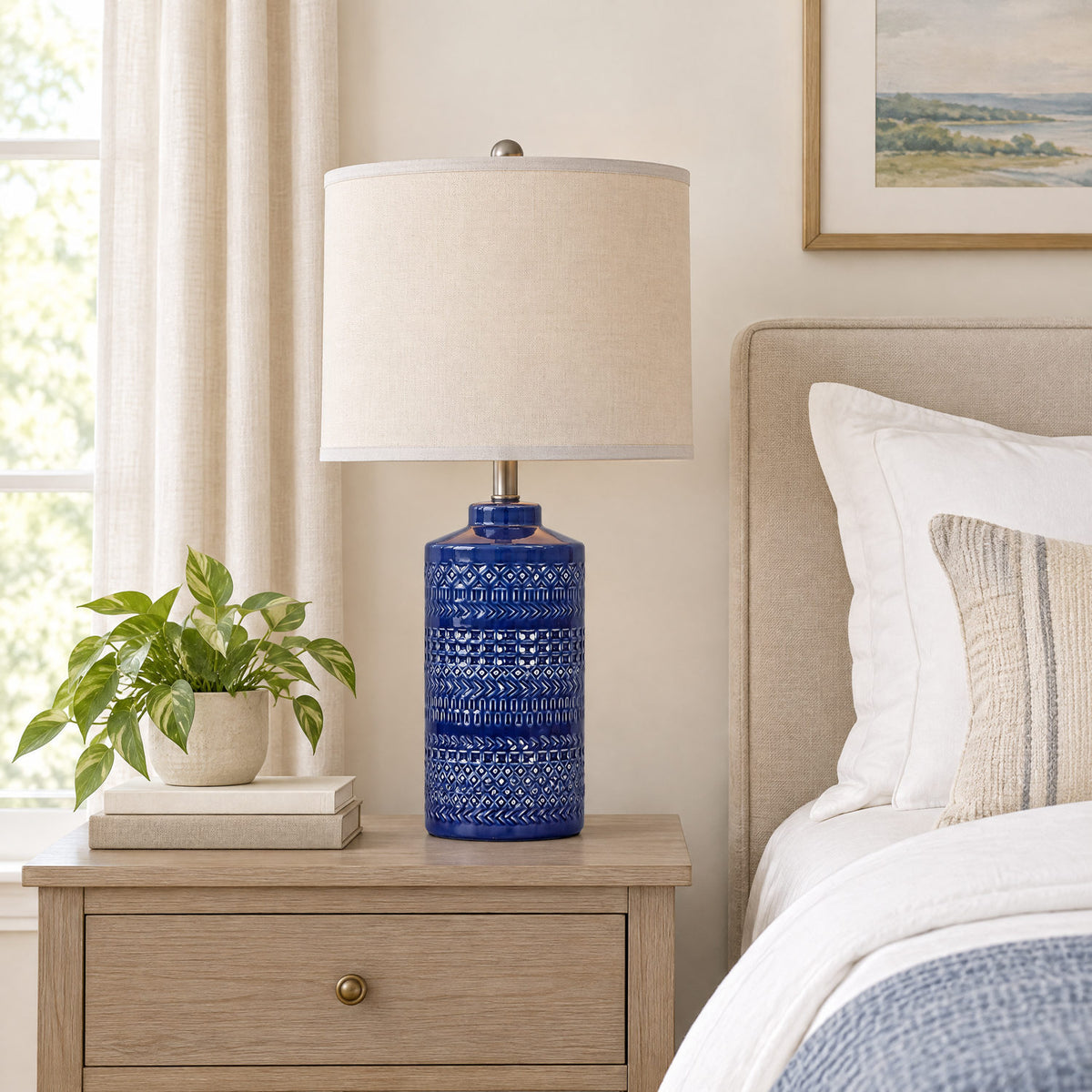 Navy blue ceramic table lamp on a bedside table to show its height